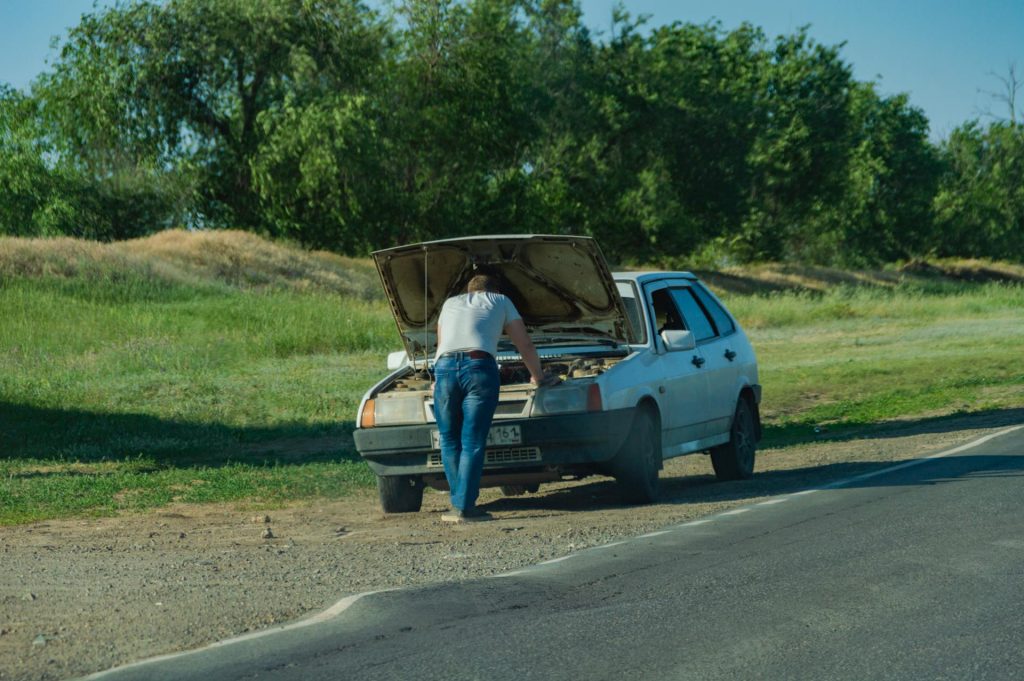 photo of a man having car problems on the roadside